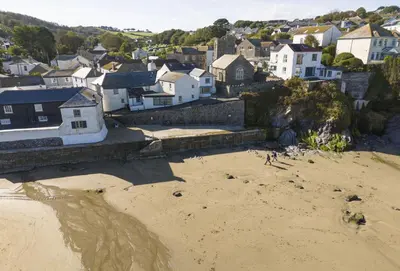 a group of people on a beach near a town at Cliff Cottage in Gorran Haven
