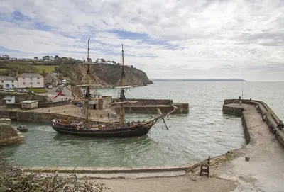 a boat is docked in a body of water at Cliff Cottage in Gorran Haven