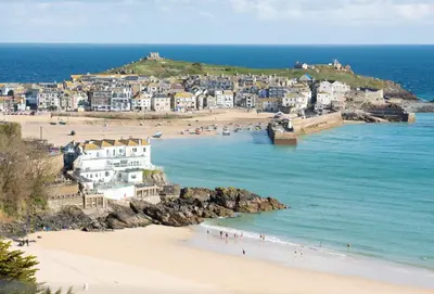 a group of people on a beach near the ocean at Copperhouse View in Hayle