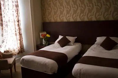 a hotel room with two beds and a window at The Grove Falmouth in Falmouth