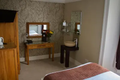 a bedroom with a mirror and a table with a sink at The Grove Falmouth in Falmouth