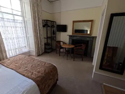 a hotel room with a bed and a fireplace at The Grove Falmouth in Falmouth