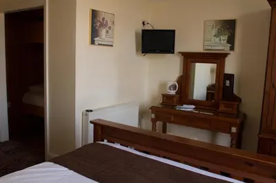 a bedroom with a bed and a dresser and a mirror at The Grove Falmouth in Falmouth