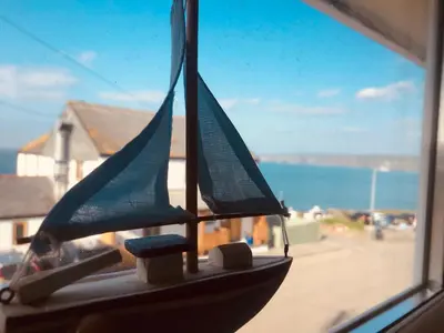 a small toy boat sitting on a window sill at Bay House Lundy Port Isaac Apartment with Sea Views & Parking in Port Isaac