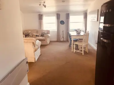 a living room with a couch and a table at Bay House Lundy Port Isaac Apartment with Sea Views & Parking in Port Isaac