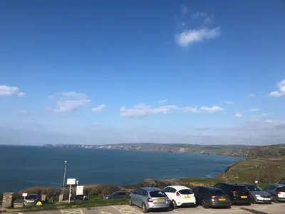a bunch of cars parked in a parking lot near the water at Bay House Lobber Port Isaac Apartment with Sea Views & Parking in Port Isaac