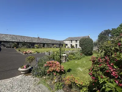 a garden with flowers and plants in front of a building at Courtyard Farm Cottages in Boscastle