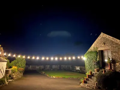 a garden at night with lights on a building at Courtyard Farm Cottages in Boscastle