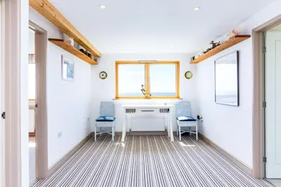 a room with two chairs and a table and a window at Dolphins in Coverack
