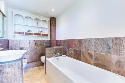 a bathroom with a tub and a toilet and a sink at Dolphins in Coverack