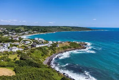 an aerial view of a beach with houses and the ocean at Dolphins in Coverack