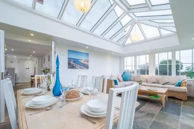 a dining room and living room with a glass ceiling at Balwest Cottage in Helston