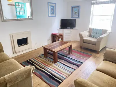 a living room with a coffee table and a tv at Porthia Cottage in St Ives