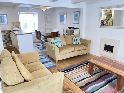 a living room with a couch and a table at Porthia Cottage in St Ives