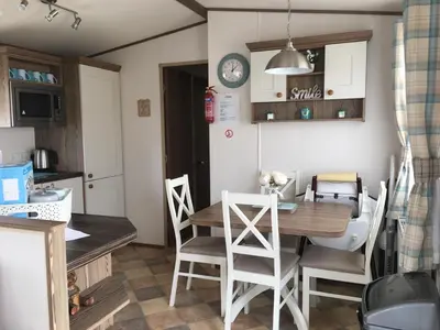 a kitchen and dining room with a table and chairs at BRANWOOD Luxury Caravan Holidays Newquay in Newquay