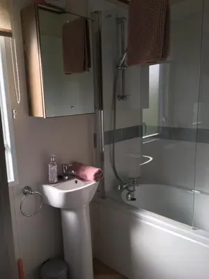 a bathroom with a sink and a shower and a tub at BRANWOOD Luxury Caravan Holidays Newquay in Newquay