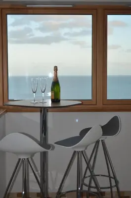 a table with two glasses and a bottle of wine at Skysail - Exceptional Sea Views in Mevagissey