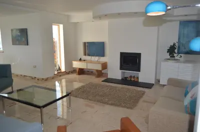 a living room with a couch and a tv at Skysail - Exceptional Sea Views in Mevagissey