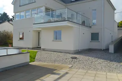 a white house with a balcony on it at Skysail - Exceptional Sea Views in Mevagissey