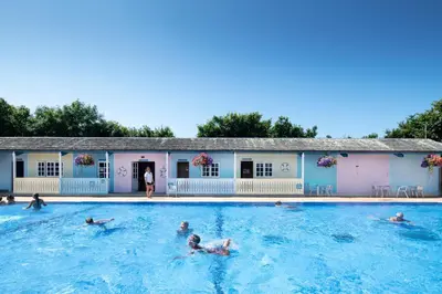 a group of people swimming in a swimming pool at Popham Cottage in Cornwall in Newquay