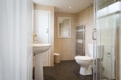 a bathroom with a toilet and a sink and a shower at Popham Cottage in Cornwall in Newquay