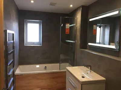a bathroom with a shower and a sink and a tub at Relax in style at my stunning Holywell Beach home in Holywell Bay