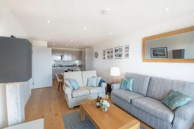 a living room with a couch and a table at Harbour Lights in Newquay