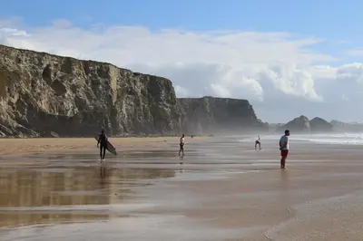 a group of people walking on the beach at Harbour Lights in Newquay