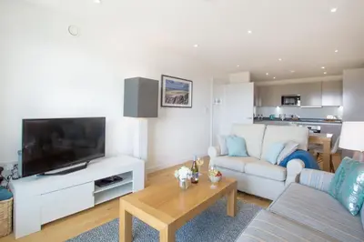a living room with a couch and a tv at Harbour Lights in Newquay