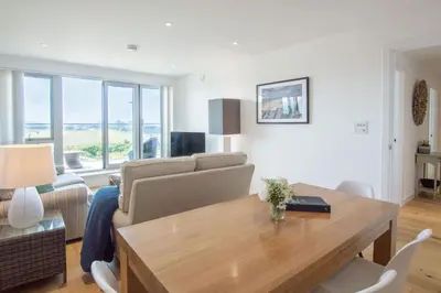 a living room with a table and a couch at Harbour Lights in Newquay