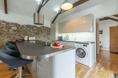 a kitchen with a counter and a washing machine at Hunter's Barn in St. Agnes