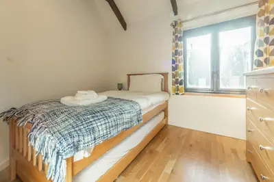 a small bedroom with a bed and a window at Hunter's Barn in St. Agnes