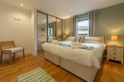 a bedroom with a large white bed and a window at Morvah in St. Agnes
