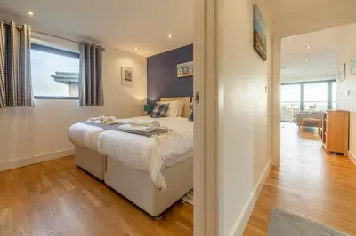 a bedroom with a bed and a room with a hallway at Morvah in St. Agnes