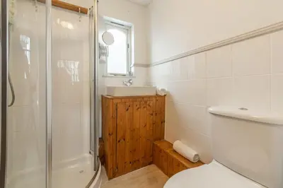 a bathroom with a shower and a toilet and a sink at Porthgwidden Cottage in Uny Lelant