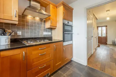 a kitchen with wooden cabinets and a stove top oven at Porthia in Hayle