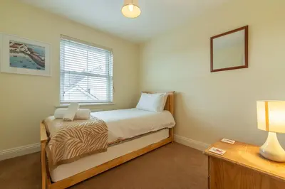 a small bedroom with a bed and a window at Porthia in Hayle