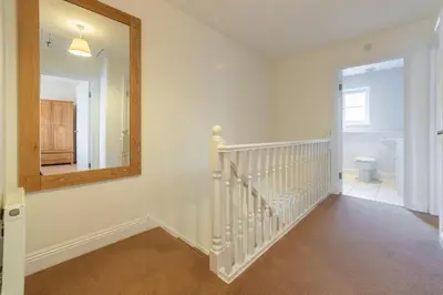 a hallway with a mirror and stairs in a home at Porthia in Hayle