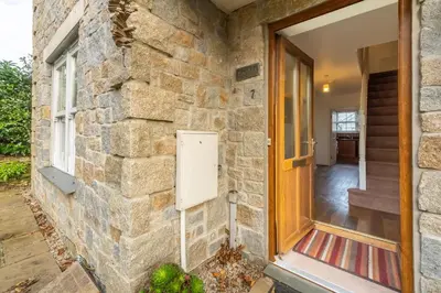 a brick wall with a door and a window at Porthia in Hayle
