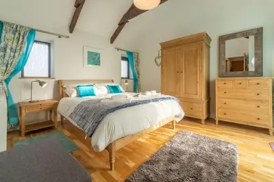 a bedroom with a bed and a dresser and a mirror at Potter's Barn in St. Agnes