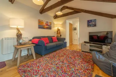 a living room with a blue couch and a rug at Potter's Barn in St. Agnes