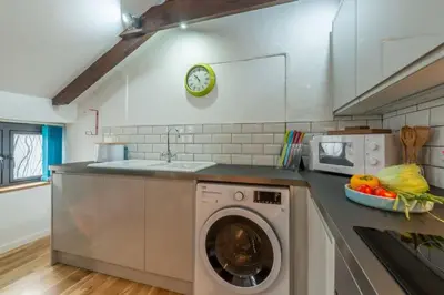 a kitchen with a washing machine and a sink at Potter's Barn in St. Agnes