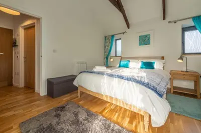 a bedroom with a large bed with blue pillows at Potter's Barn in St. Agnes
