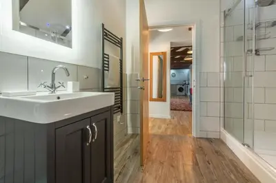 a bathroom with a sink and a glass shower at Potter's Barn in St. Agnes