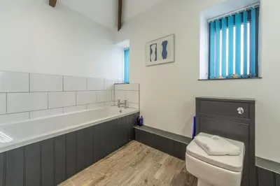 a bathroom with a toilet and a sink and a tub at Potter's Barn in St. Agnes
