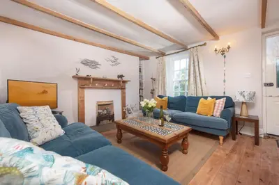 a living room with two blue couches and a coffee table at Roseneath in St. Agnes