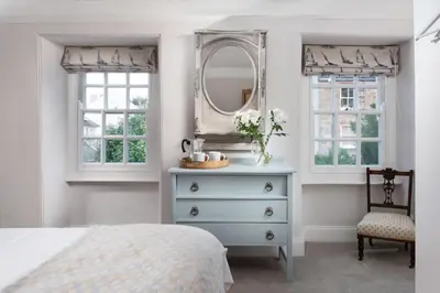 a bedroom with a dresser and a mirror at Roseneath in St. Agnes