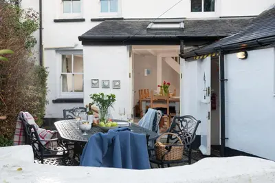 an outdoor patio with a table and chairs at Roseneath in St. Agnes