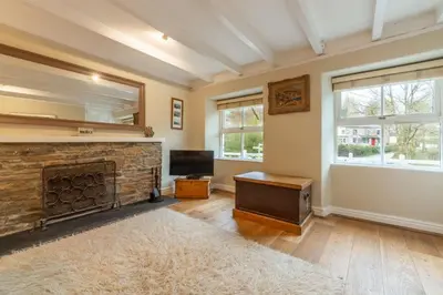 a living room with a fireplace and a television at Rose in Vale Cottage in Perranzabuloe