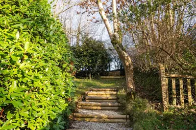 a set of stone stairs in a garden at Rose in Vale Cottage in Perranzabuloe